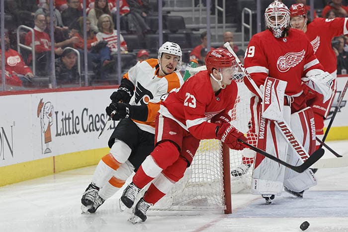 Detroit Red Wings left wing Lucas Raymond (23) skates with the puck chased by Philadelphia Flyers center Morgan Frost (48) in the first period at Little Caesars Arena.