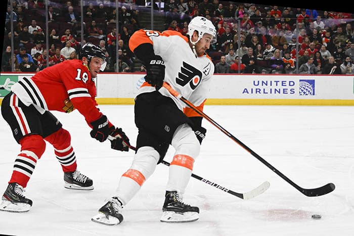 Chicago Blackhawks center Jonathan Toews (19) and Philadelphia Flyers center Kevin Hayes (13) chase the puck  during the first period at  the United Center.