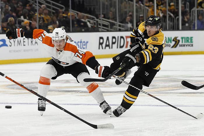 Boston Bruins left wing Brad Marchand (63) lets go with a shot past Philadelphia Flyers right wing Owen Tippett (74) during the first period at TD Garden.