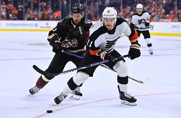 Jan 5, 2023; Philadelphia, Pennsylvania, USA; Philadelphia Flyers right wing Travis Konecny (11) pushes the puck past Arizona Coyotes left wing Michael Carcone (53) in the third period at Wells Fargo Center. 