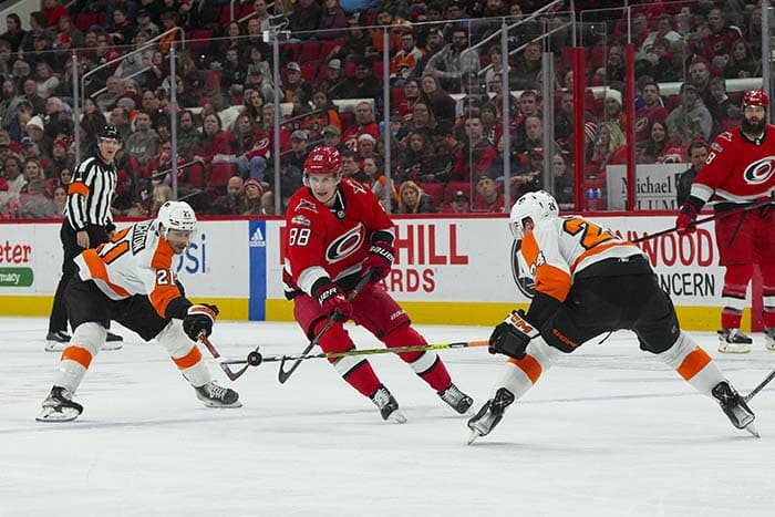 Carolina Hurricanes center Martin Necas (88) tries to carry the puck between Philadelphia Flyers defenseman Nick Seeler (24) and center Scott Laughton (21) during the first period at PNC Arena. 