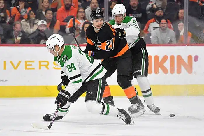 Philadelphia Flyers center Scott Laughton (21) battles for the puck with Dallas Stars center Roope Hintz (24) and  defenseman Nils Lundkvist (5) during the second period at Wells Fargo Center. 