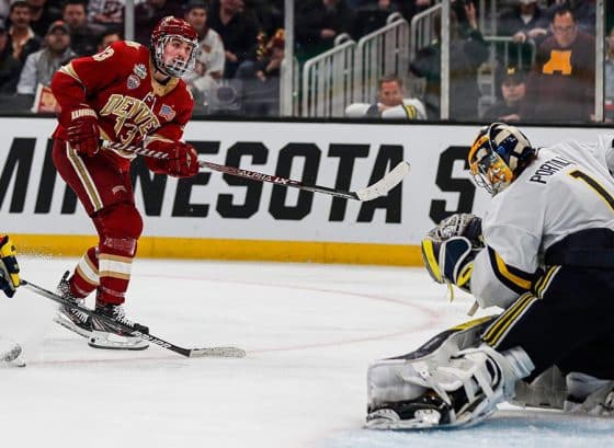 Michigan goaltender Erik Portillo makes a save against Denver forward Massimo Rizzo during overtime of U-M's 3-2 loss in the Frozen Four semifinal at the TD Garden in Boston on Thursday, April 7, 2022.