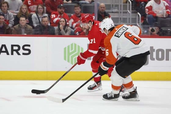Detroit Red Wings center Dylan Larkin (71) skates with the puck defended by Philadelphia Flyers defenseman Travis Sanheim (6) in the second period at Little Caesars Arena.
