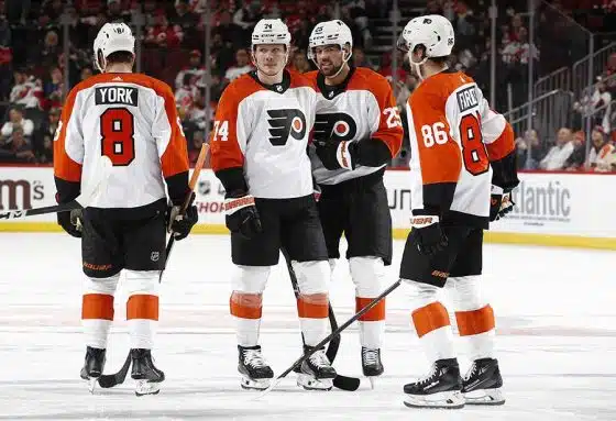 Cam York #8, Owen Tippett #74, Ryan Poehling #25, and Joel Farabee #86 of the Philadelphia Flyers huddle during the third period against the New Jersey Devils at Prudential Center on December 19, 2023 in Newark, New Jersey. The Flyers won 3-2 in overtime.