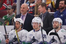 CHICAGO, ILLINOIS - OCTOBER 22: Head coach Rick Tocchet of the Vancouver Canucks talks with assistant coach Yogi Svejkovsky against the Chicago Blackhawks during the first period at the United Center on October 22, 2024 in Chicago, Illinois.