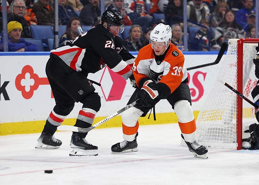 Dec 18, 2025; Buffalo, New York, USA; Philadelphia Flyers right wing Matvei Michkov (39) tries to play the puck as Buffalo Sabres defenseman Rasmus Dahlin (26) defends during the third period at KeyBank Center.